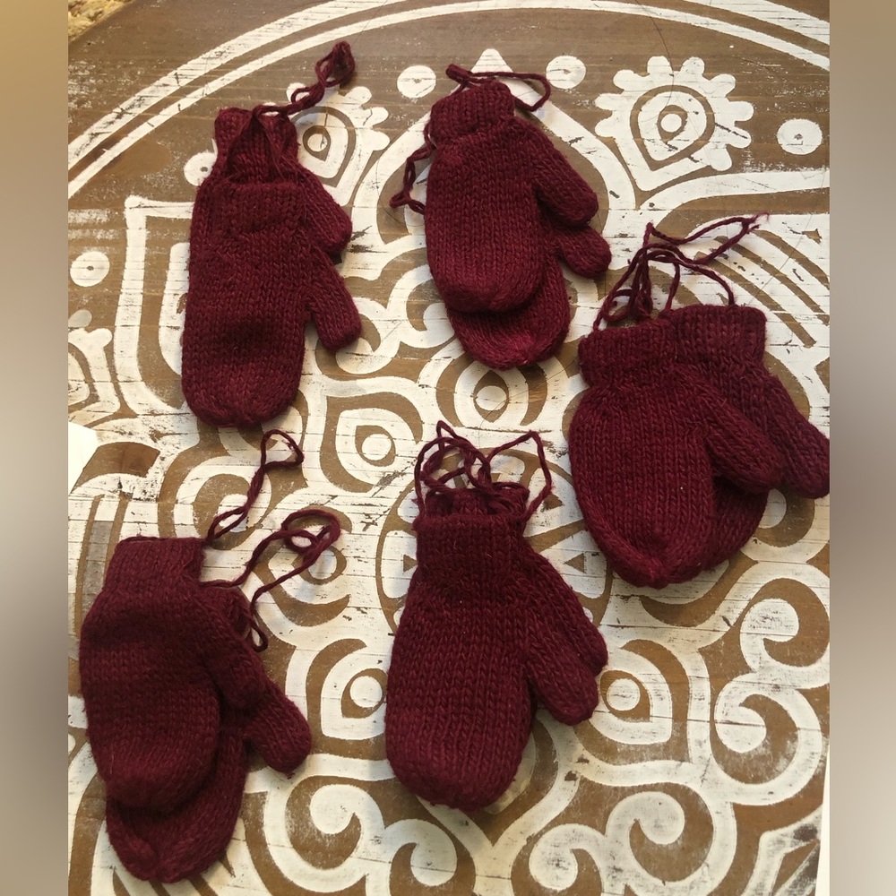 Mini red crimson knitted gloves.